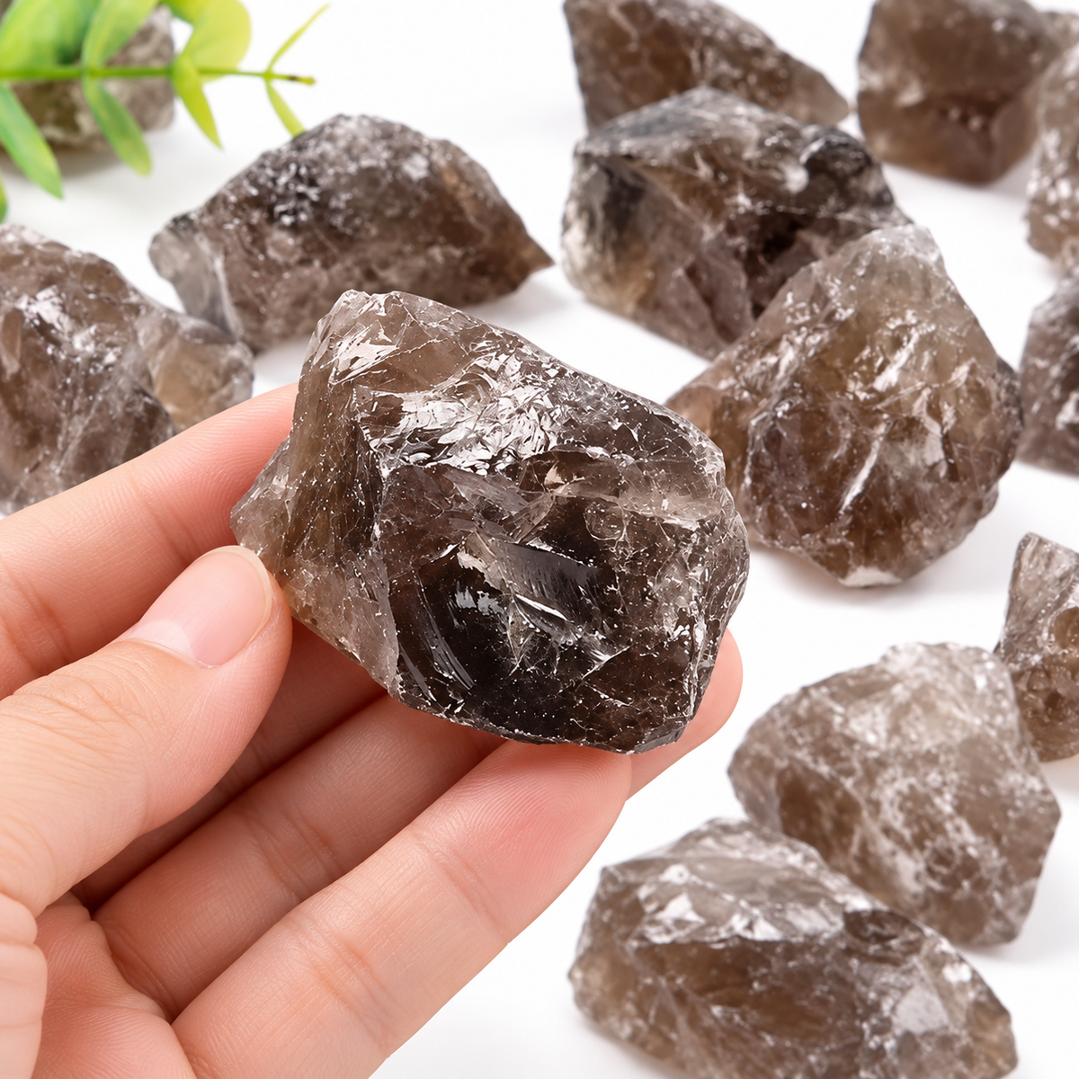 Hand holding a Smoky Quartz raw crystal piece showing natural size, texture, and smoky color